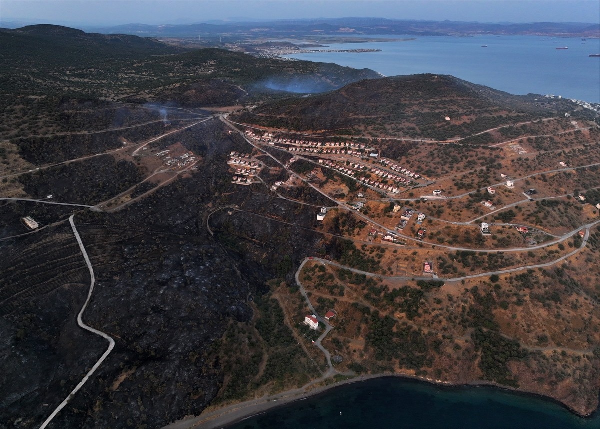 İzmir'in Dikili ilçesinde ormanlık alanda başlayan ve yerleşim yerlerine yaklaşan yangına havadan...