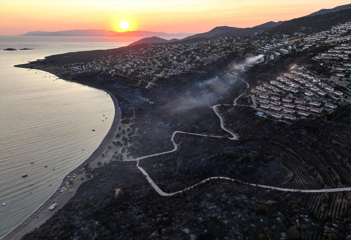 İzmir'in Dikili ilçesinde ormanlık alanda başlayan ve yerleşim yerlerine yaklaşan yangına havadan...