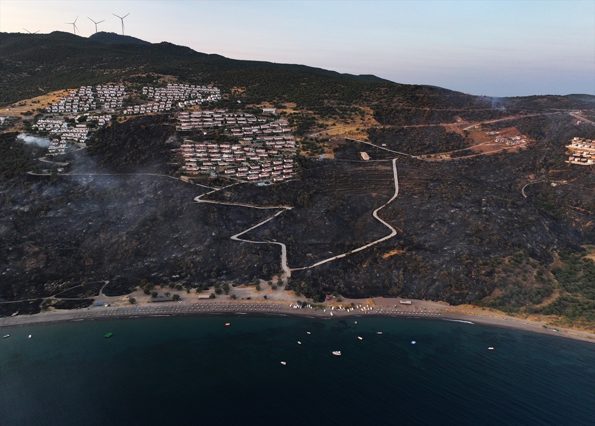 İzmir'in Dikili ilçesinde ormanlık alanda başlayan ve yerleşim yerlerine yaklaşan yangına havadan...