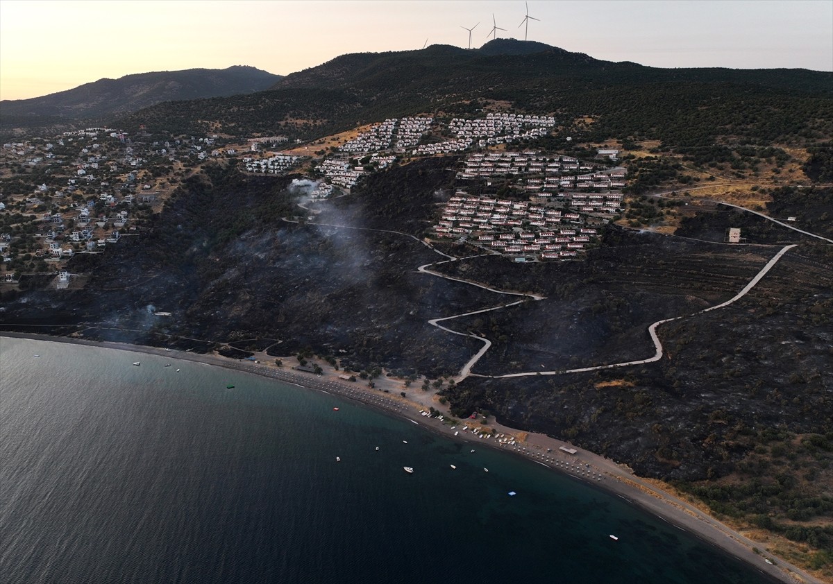 İzmir'in Dikili ilçesinde ormanlık alanda başlayan ve yerleşim yerlerine yaklaşan yangına havadan...