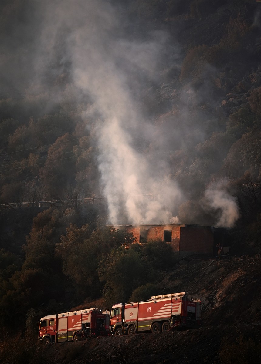İzmir'in Dikili ilçesinde ormanlık alanda başlayan ve yerleşim yerlerine yaklaşan yangına havadan...