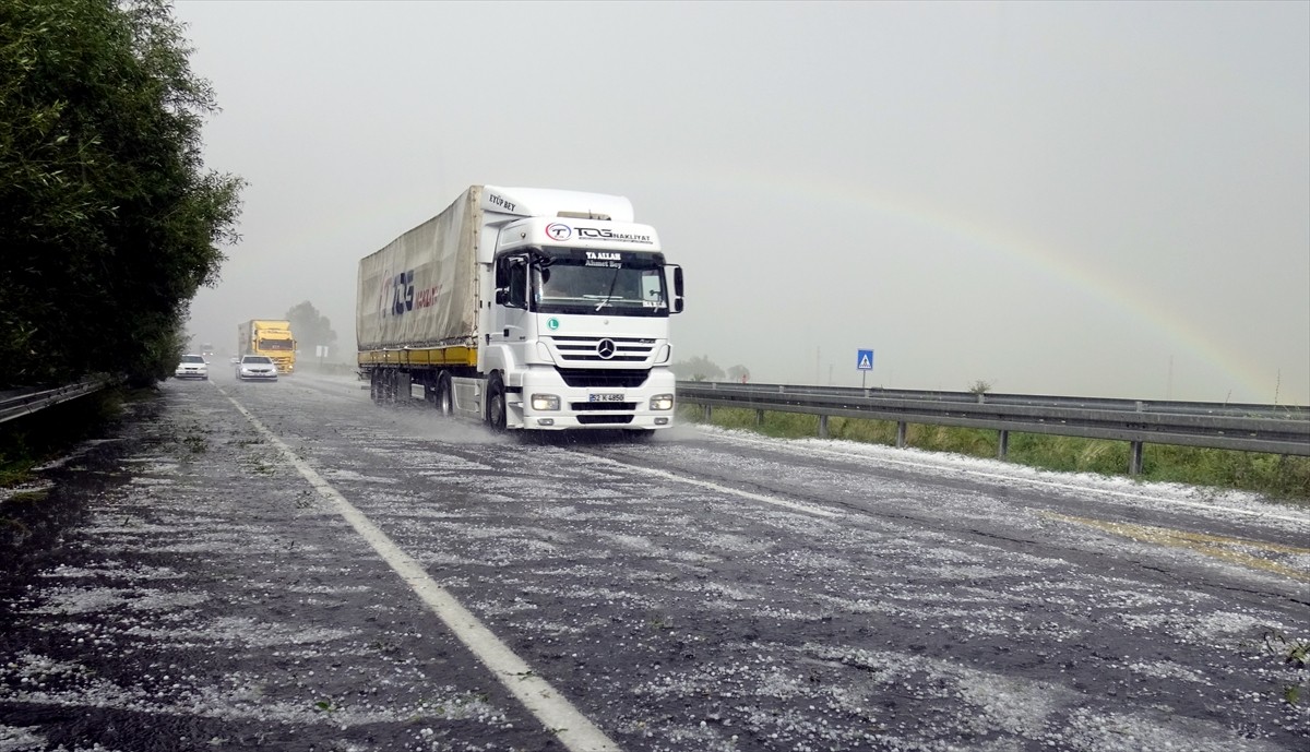 Kars'ta sağanak sonrası yağan dolu, kara yolunu ve evlerin bahçelerini beyaz örtüyle kapladı.