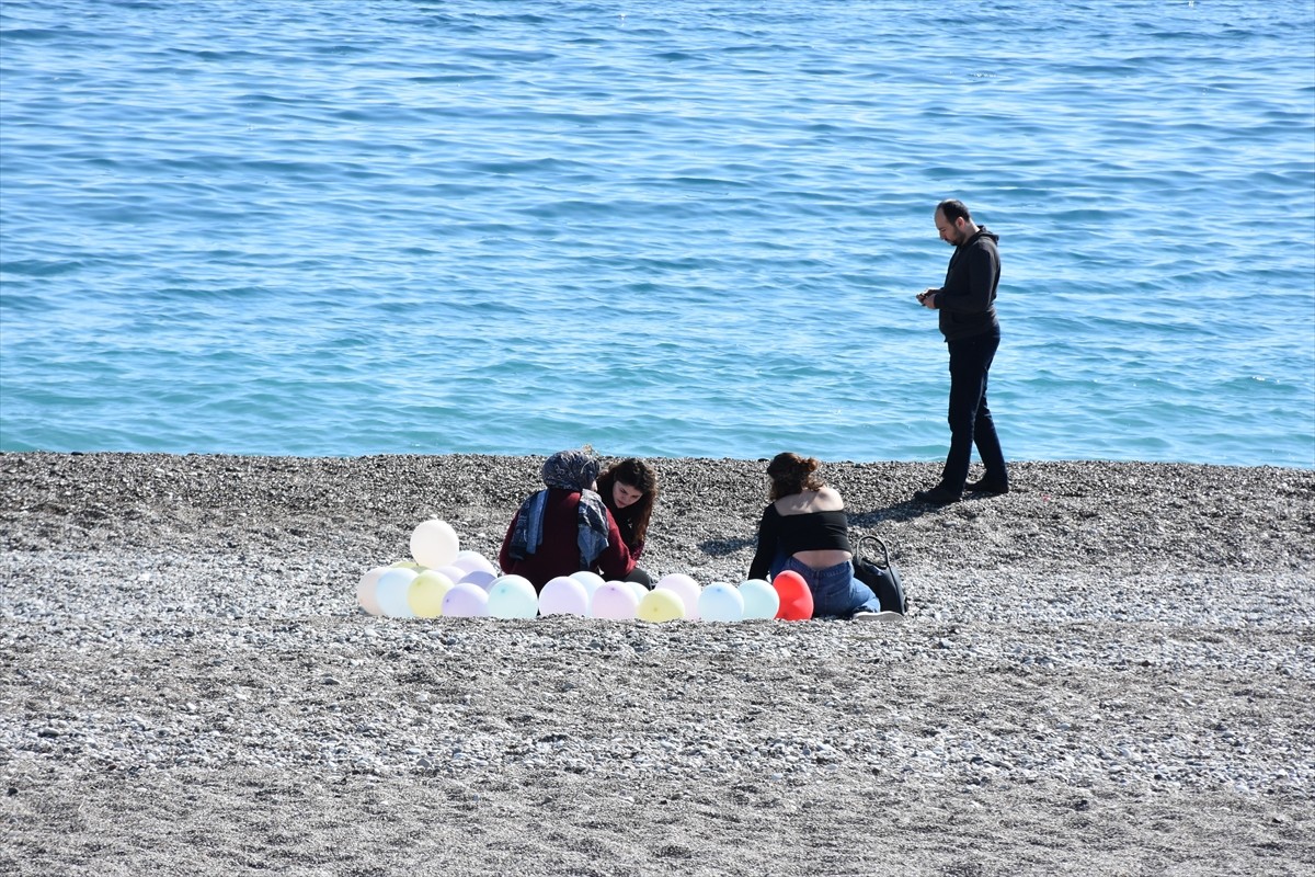 Antalya'da güneşli havayı değerlendirmek isteyen kent sakinleri ile turistler sahillerde vakit...