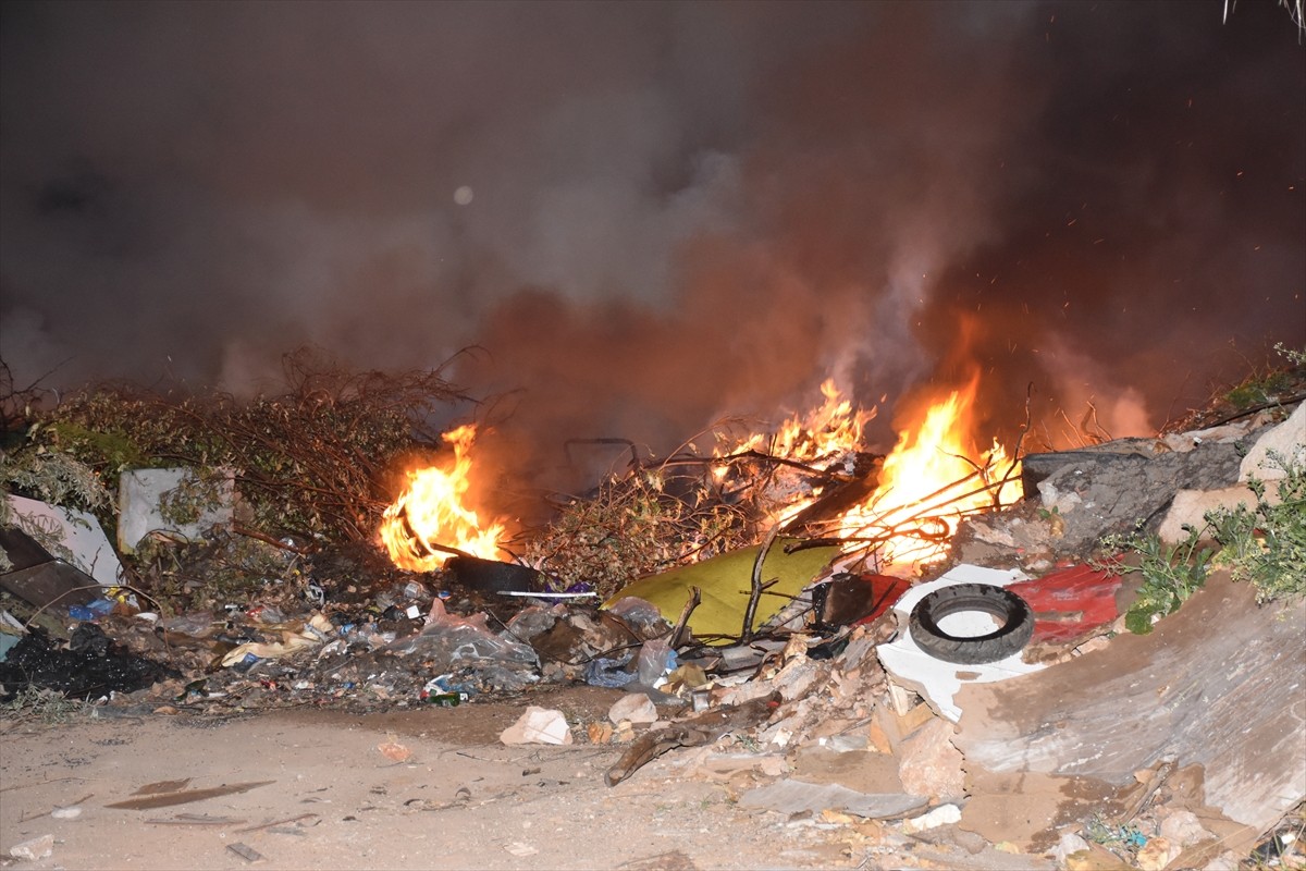 Antalya'nın Kepez ilçesinde, atıkların bulunduğu arazide çıkan yangına itfaiye ekiplerince...