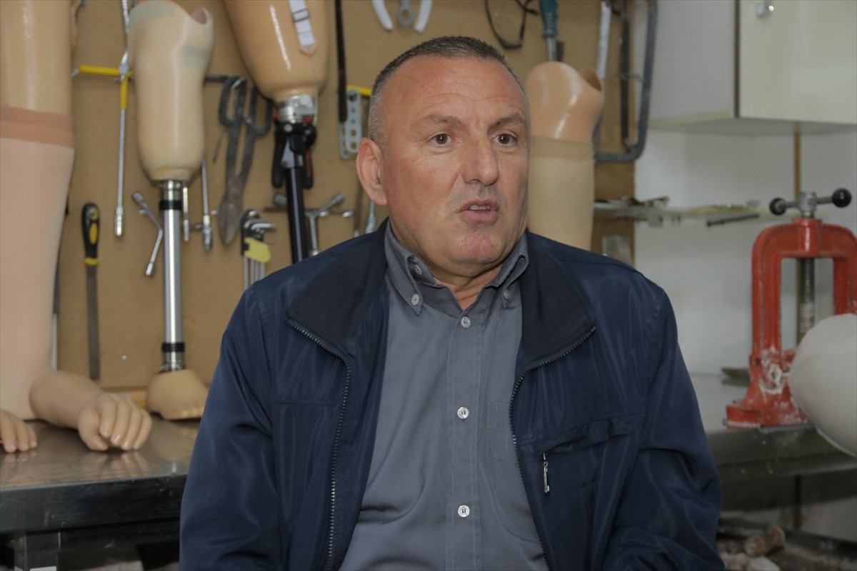 Arnavutluk'un başkenti Tiran'da, protez kol ve bacaklar kullanan İzet Onuzi (solda), atölyesinde...