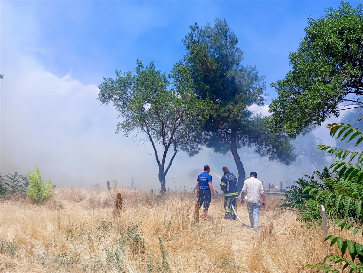 Denizli'nin Çivril ilçesindeki mezarlıktaki otluk alanda çıkan yangın, itfaiye ekiplerinin...