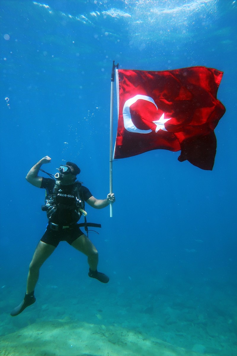 Muğla'nın Fethiye ilçesinde bir dalış okulunun dalgıçları, 30 Ağustos Zafer Bayramı nedeniyle su...