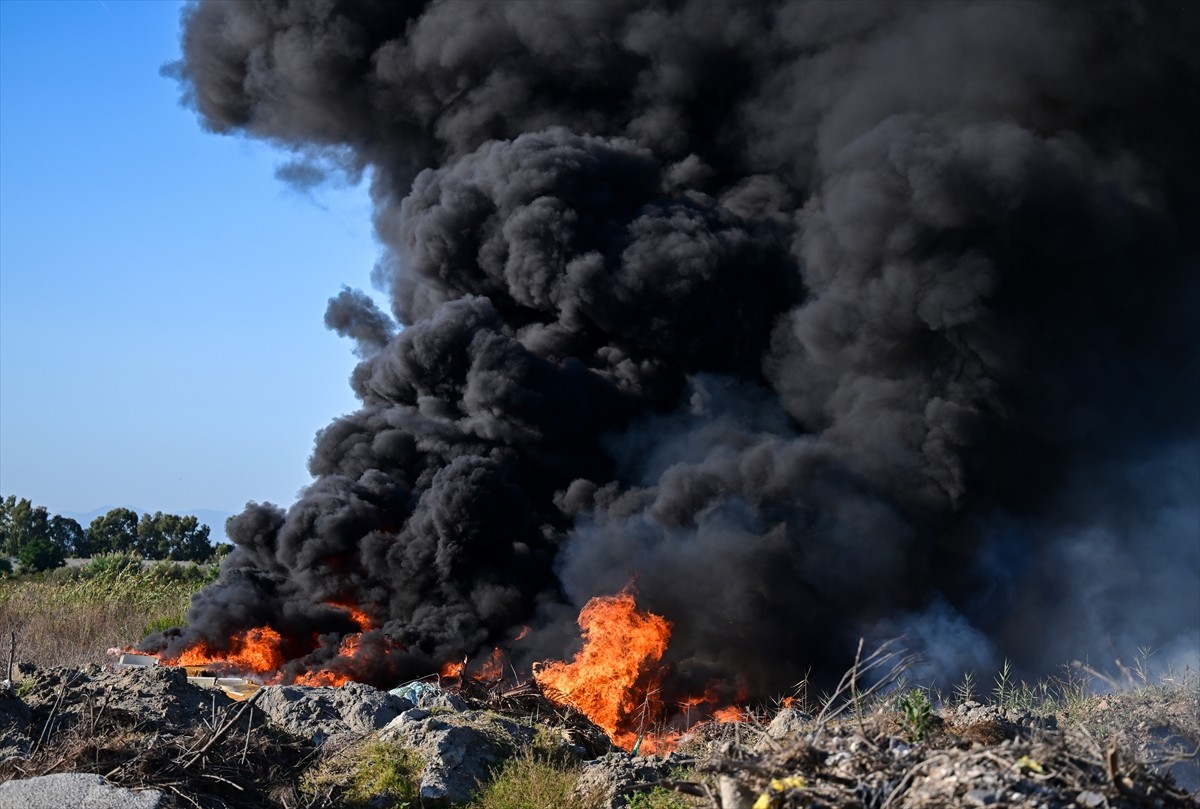 Antalya'nın Aksu ilçesinde çöp ve molozların bulunduğu alanda çıkan yangın ekiplerce...