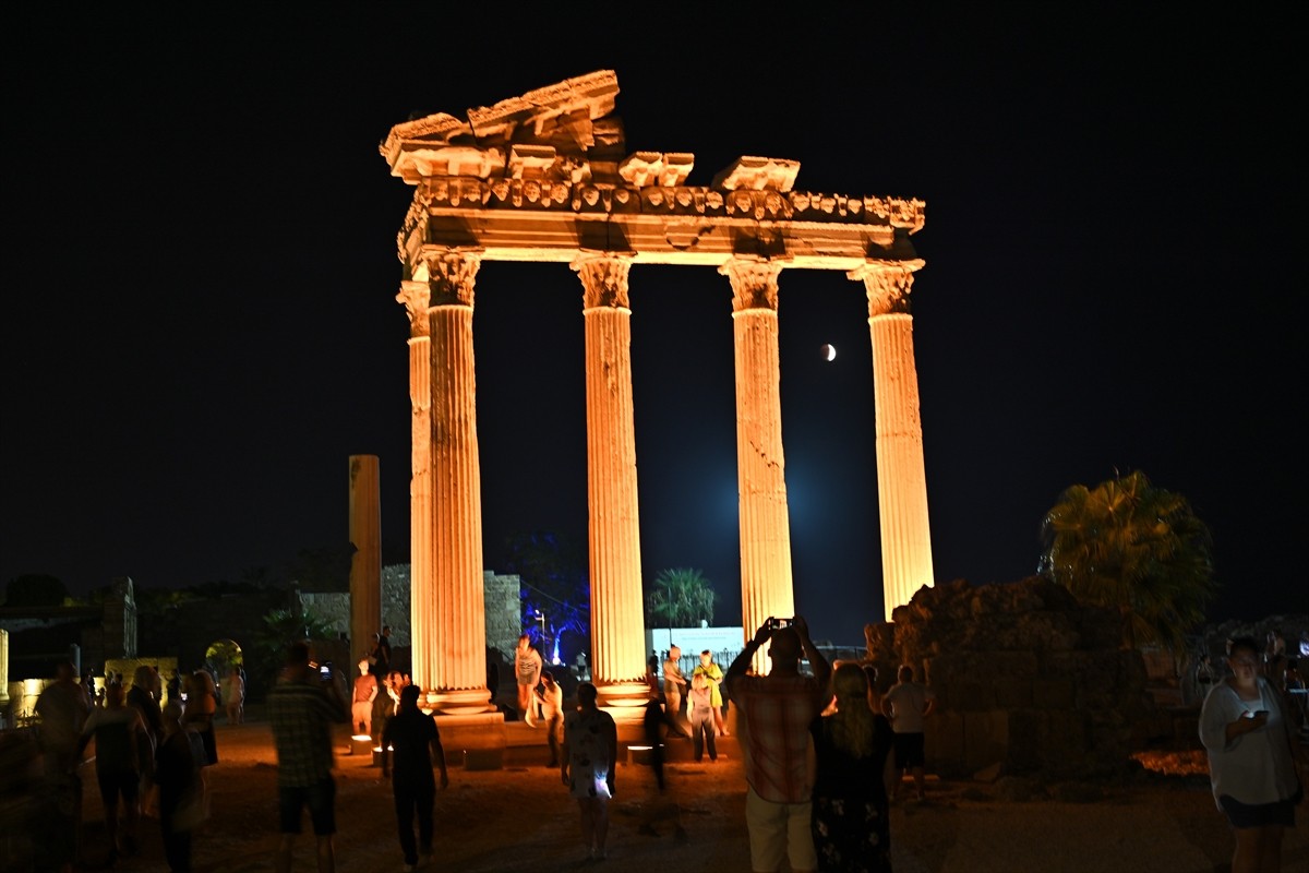 Antalya'nın Manavgat ilçesinde yerli ve yabancı turistler, Side Antik Kenti'nde kırmızı renginden...