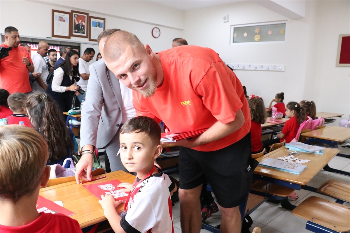 Samsunsporlu futbolcular, 1. sınıfa başlayan öğrencilere defter, kalem ve çam fidanı hediye etti....