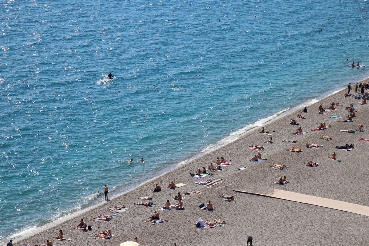 Hava sıcaklığının 28 derece olarak kaydedildiği Antalya'da, denize giren ve güneşlenenler...